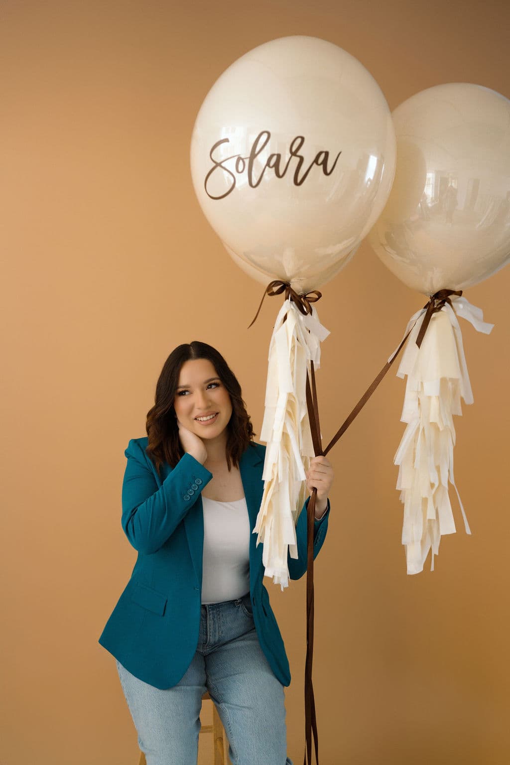 Baby letters beside a pastel balloon wall for a baby shower
