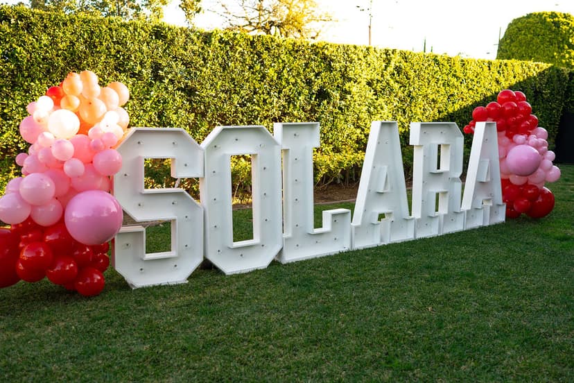 Friends celebrating around light letters at a Galentines event